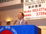 集会で報告する佐藤退職者連合会長代行